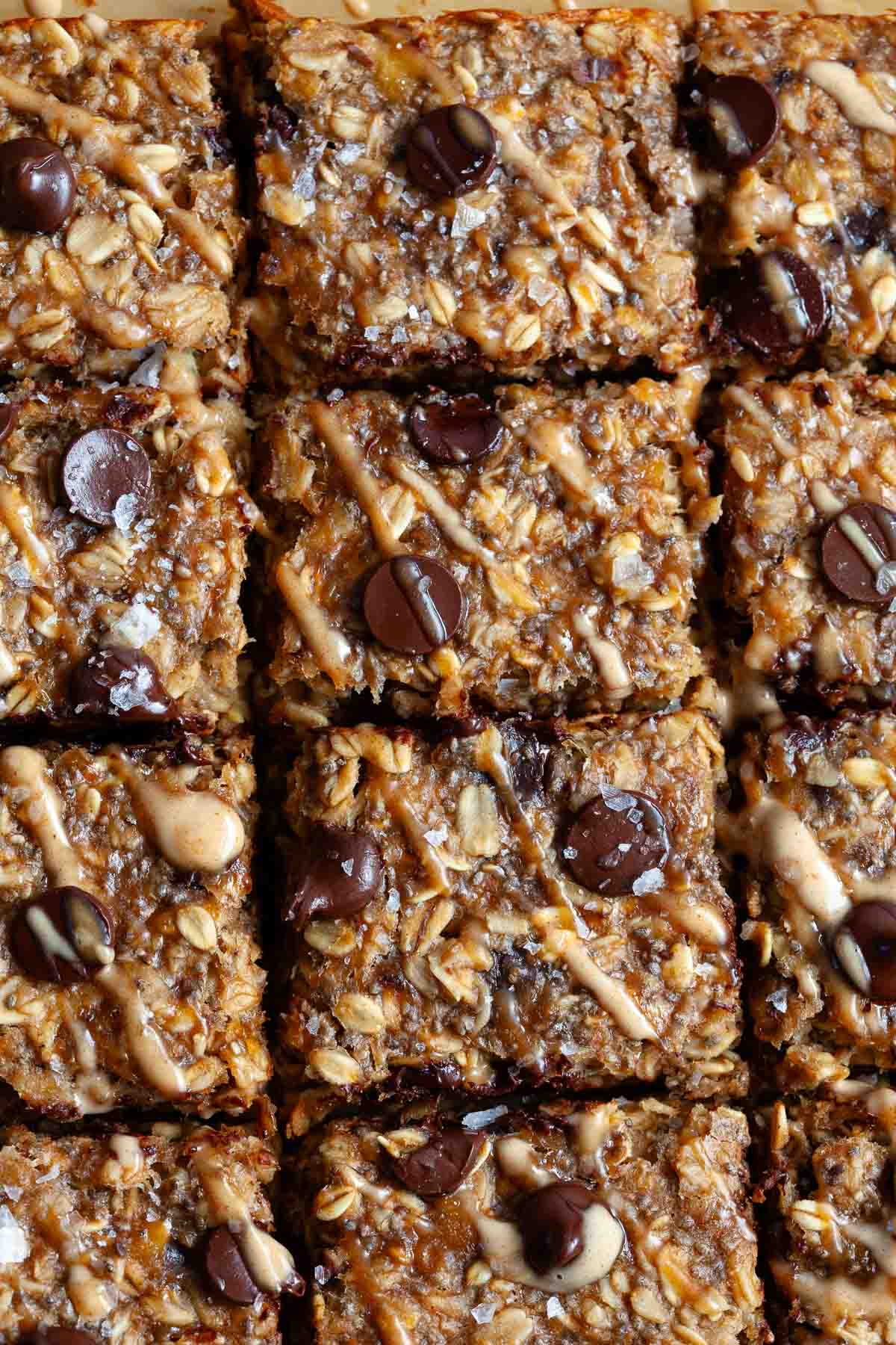 peanut butter banana chocolate chip oat bars with peanut butter drizzle and flaky sea salt cut into squares