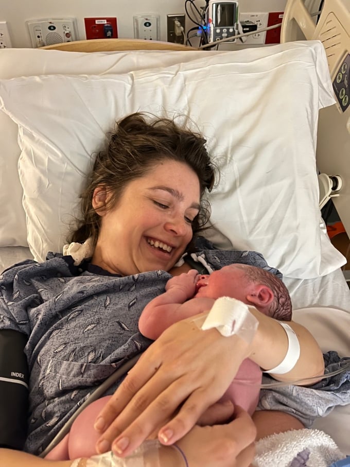 woman in hospital bed with baby laid on her chest